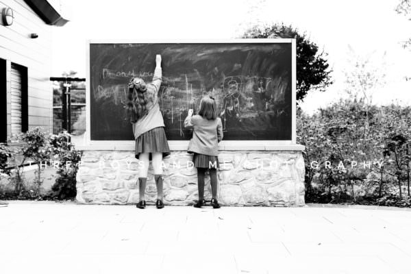 back to school photoshoot in Bexley Kent two girls drawing on chalk board