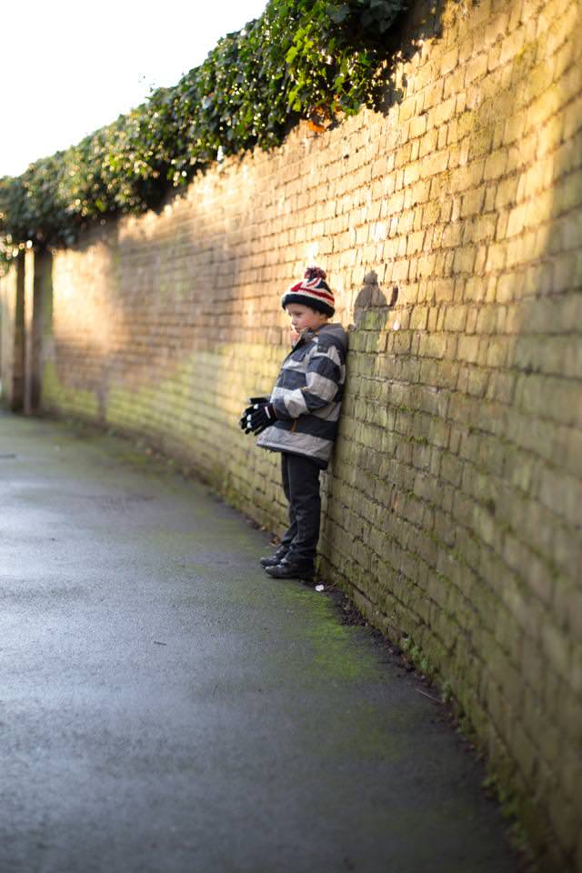 boy leaning against wall in pretty light Sevenoaks Family photographer 3 Boys and Me Photography