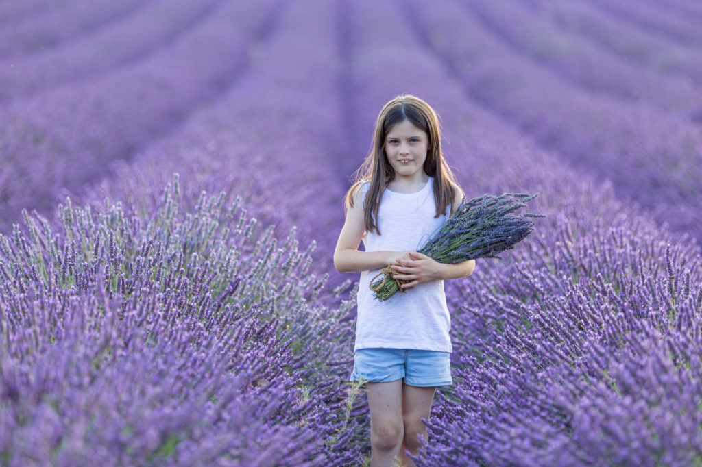 young girl standing in large field of lavender at castle farm shoreham taken at her lavender portrait shoot