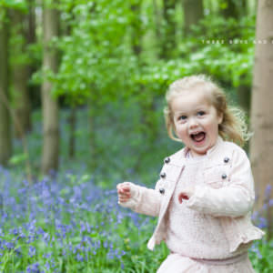 little girl dancing and smiling in the kent bluebells at her bluebell photoshoot in bexley