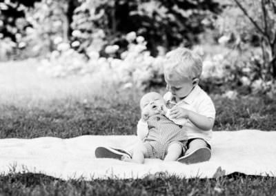 sweet moment between toddler and his newborn baby brother at their outdoor newborn shoot in Shoreham Kent