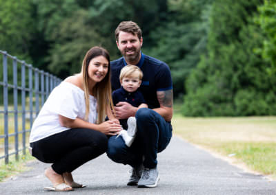 mum, dad and baby boy, crouched down low for a natural family portrait in Bexley