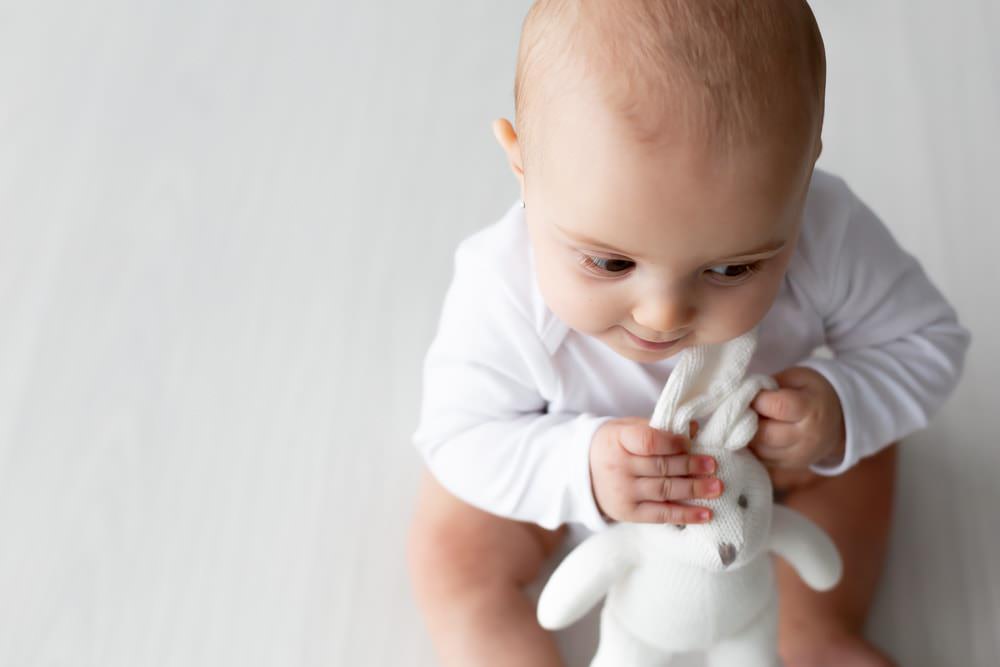 baby girl wearing white holding white bunny at her baby studio shoot in Bexley