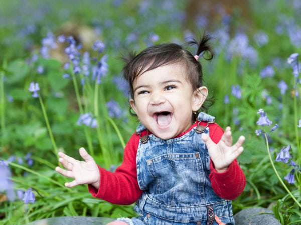 little girl with bunchies sat in the bluebells with a stunning smile at her Bexley family photoshoot
