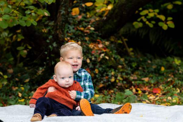 two little brothers sat on a blanket at their family autumn photoshoot at Great comp garden Sevenoaks