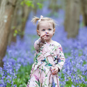 little girl stood in the bluebells at Riverhill Himalayan Gardens at her Sevenoaks family Bluebell photoshoot