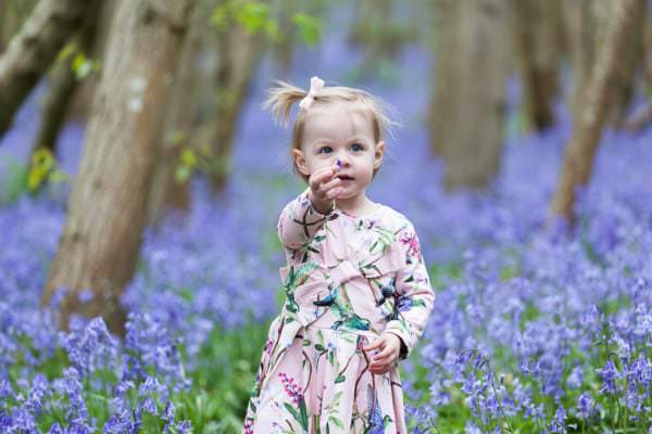little girl stood in the bluebells at Riverhill Himalayan Gardens at her Sevenoaks family Bluebell photoshoot