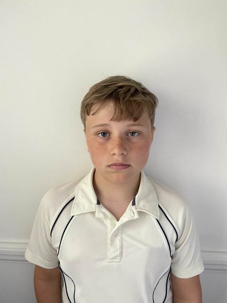 young boy having passport photo taken at home with smart phone, using white reflector to bounce light back in and elimiate shadows