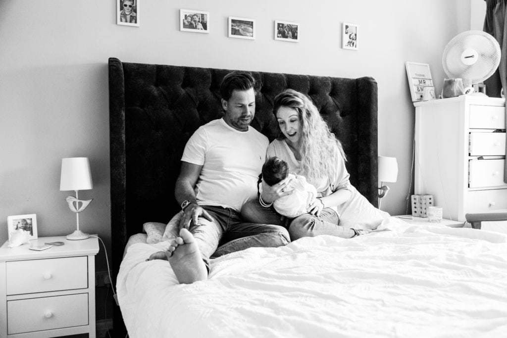 mummy and daddy and newborn baby girl in black and white share a quiet moment at their newborn family photoshoot in sevenoaks