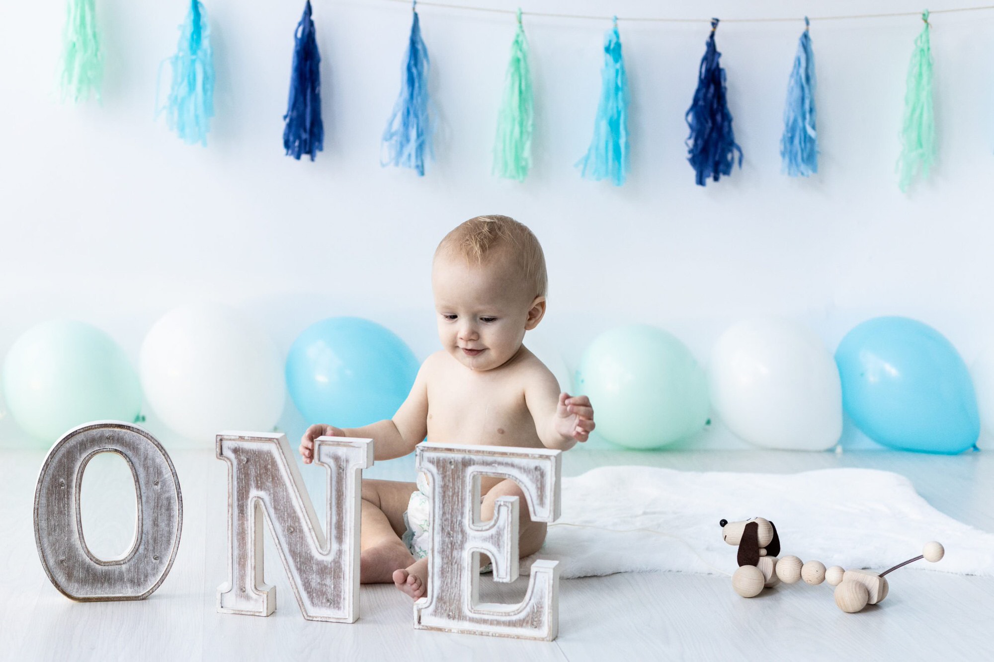 little boy with ONE wooden letters at his Bexley cake smash photoshoot