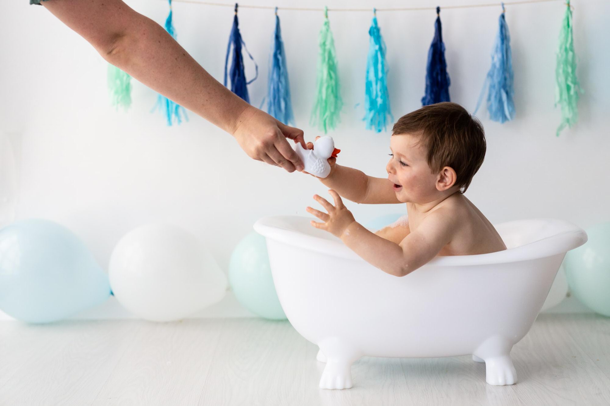 little boy in roll top bath at his Bexley cake smash shoot