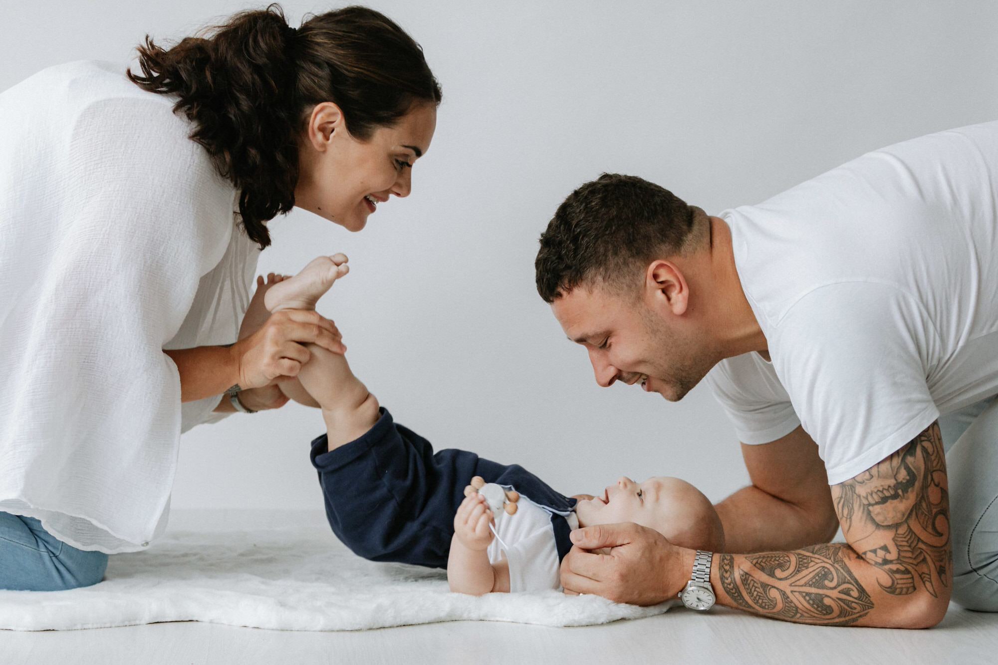 mummy and daddy playing with their baby boy laughing at his Kent baby photoshoot in Bexley