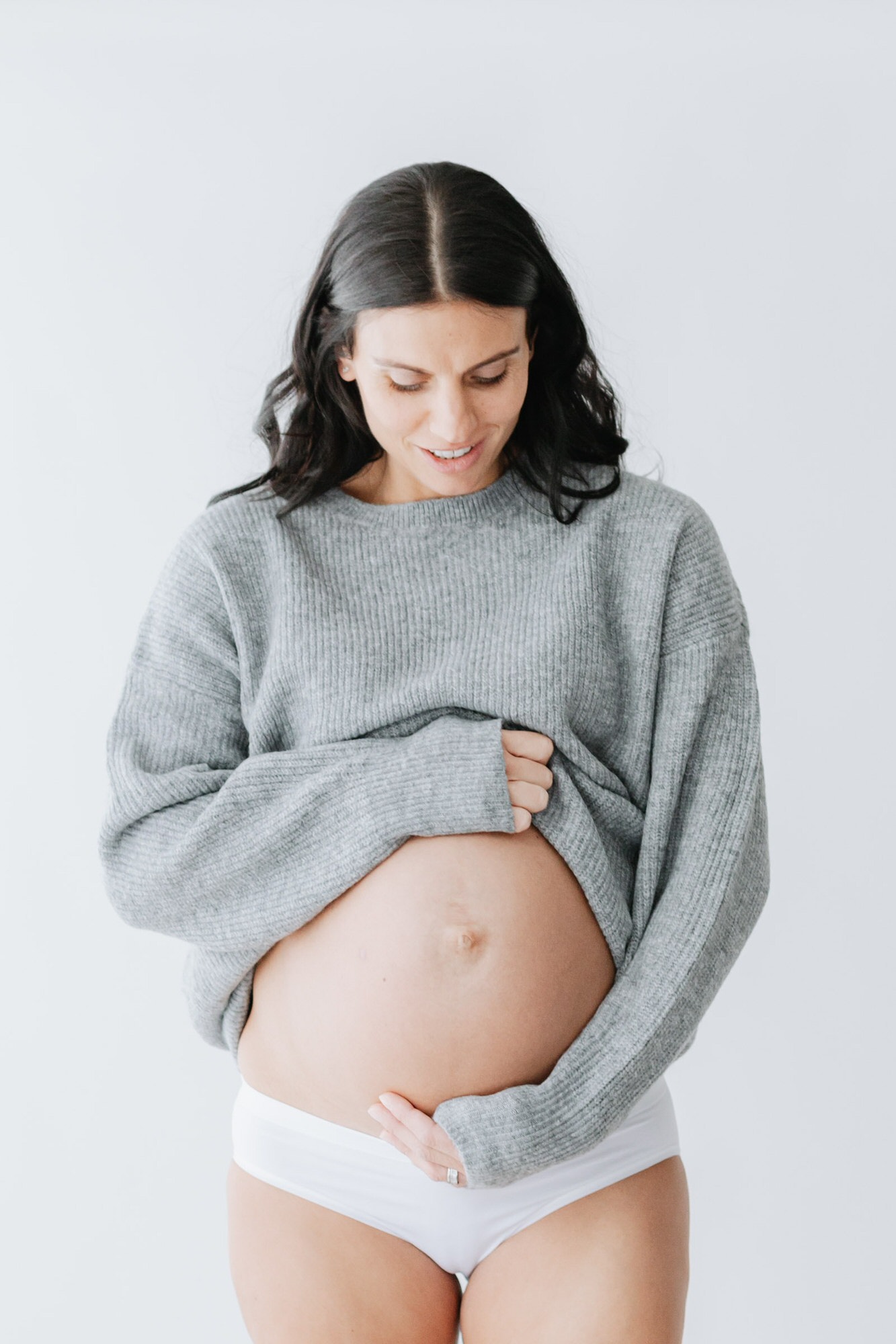 beautiful image of a pregnant mummy to be, wearing grey jumper at her kent maternity photoshoot in bexley