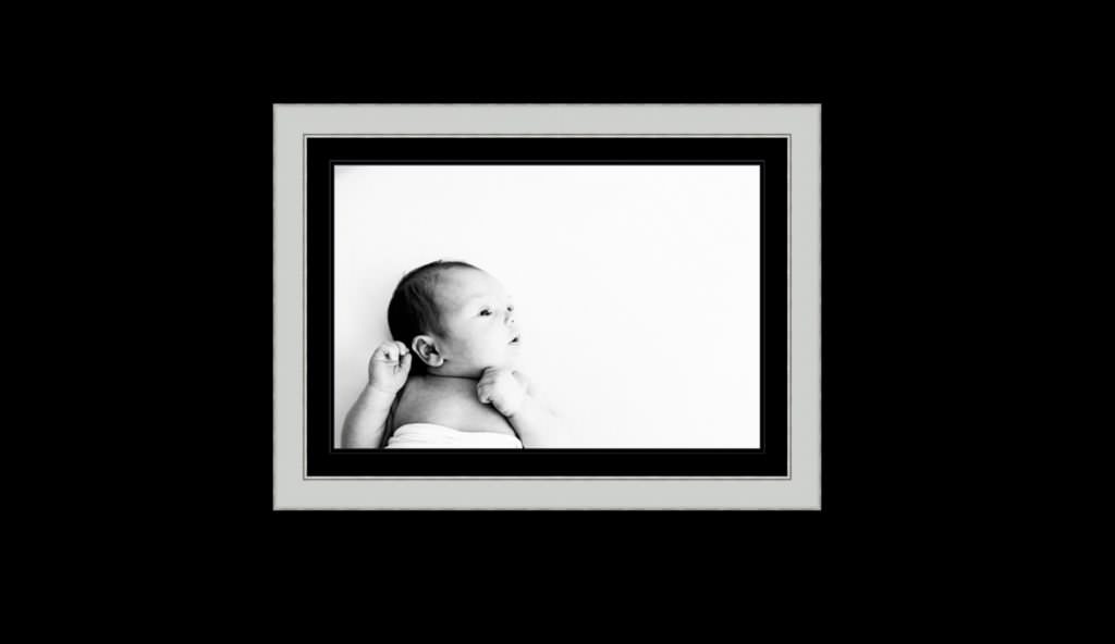 photograph of a newborn baby in a silver frame with a black mount taken at a kent newborn photoshoot
