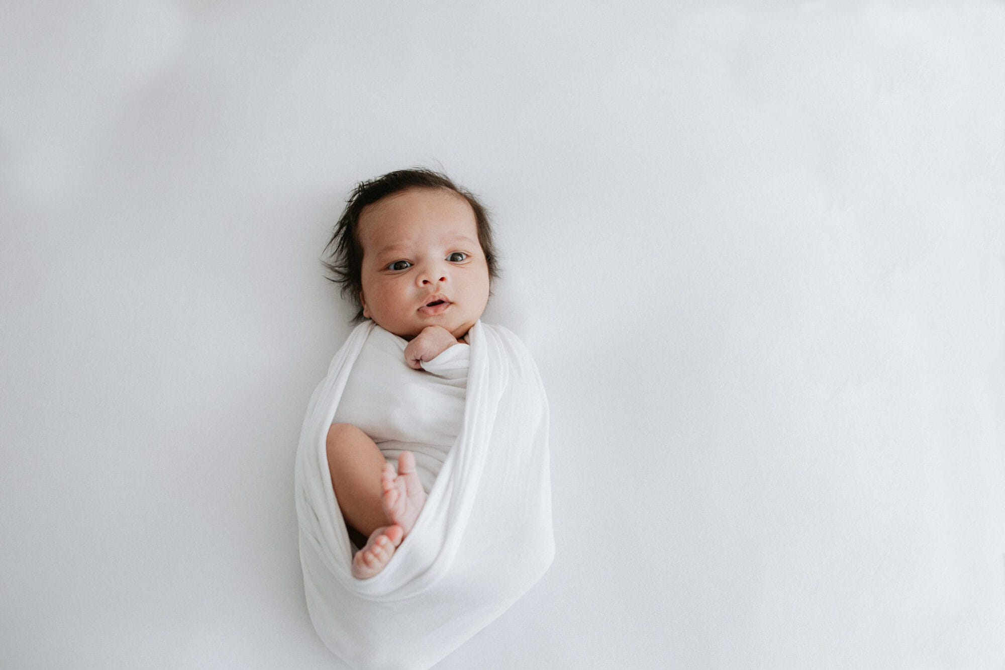 beautiful baby girl wrapped in white at her kent newborn photoshoot in bexley