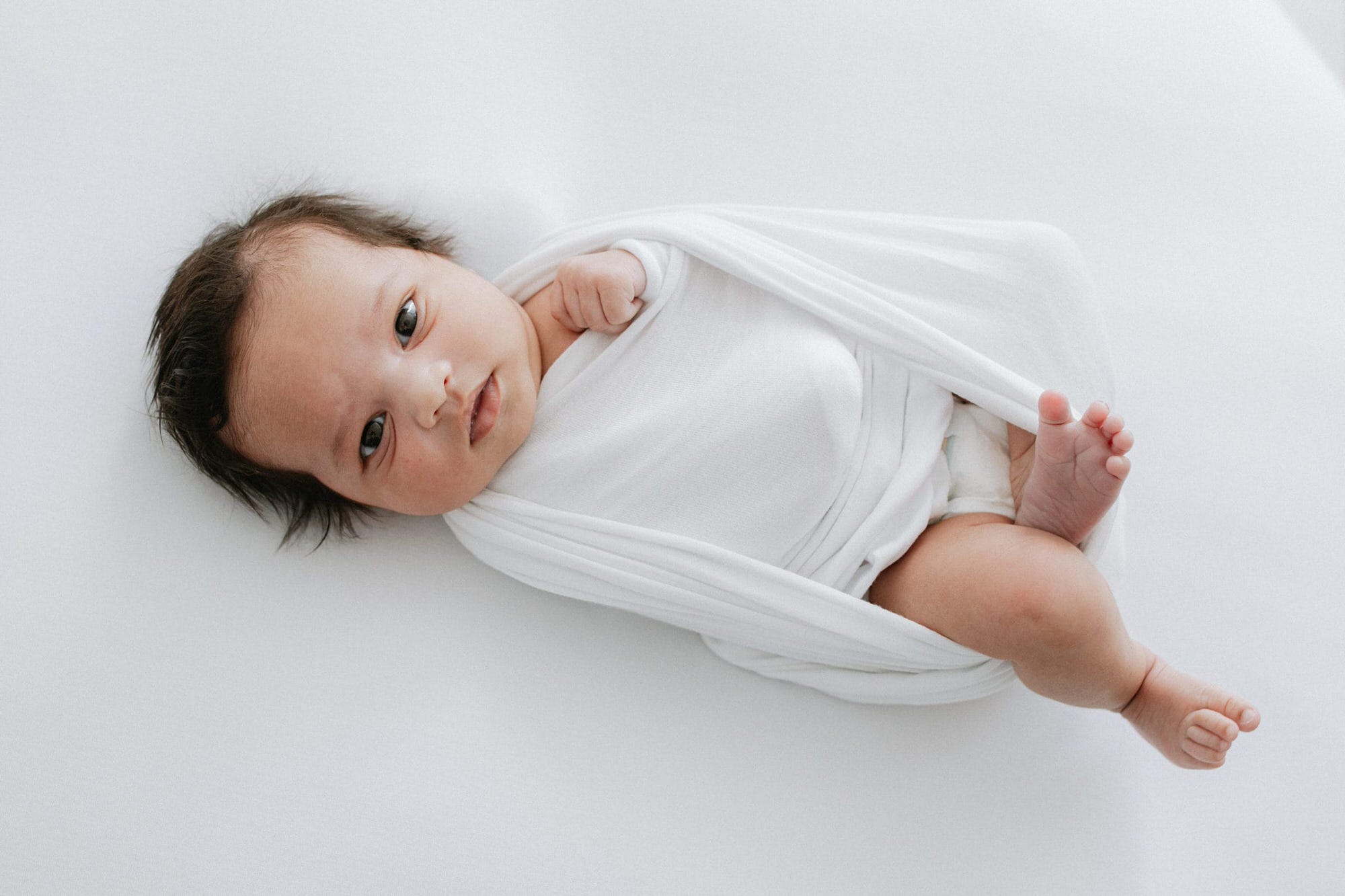 beautiful baby girl wrapped in white at her kent newborn photoshoot in bexley