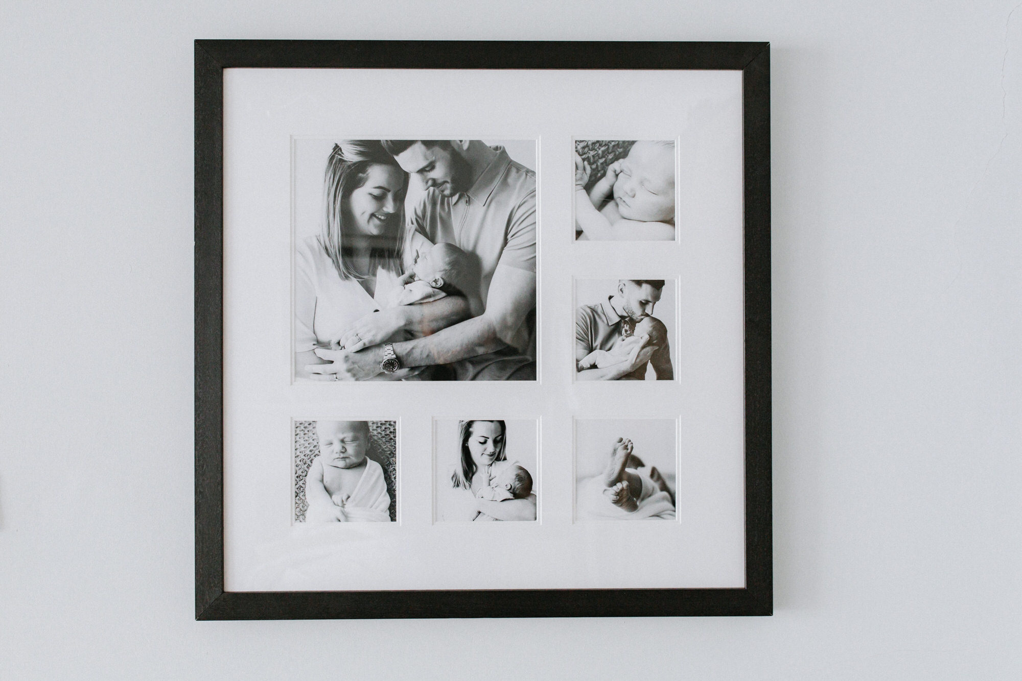wooden frame showcasing several images from a newborn photoshoot from Kent newborn photographer Nina Callow studio in Bexley