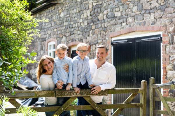 family of four with two young boys laughing at their Kent family photoshoot Great Comp Gardens Sevenoaks