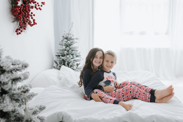 brother and sister in Christmas pyjamas at their Kent Christmas photoshoot in Bexley