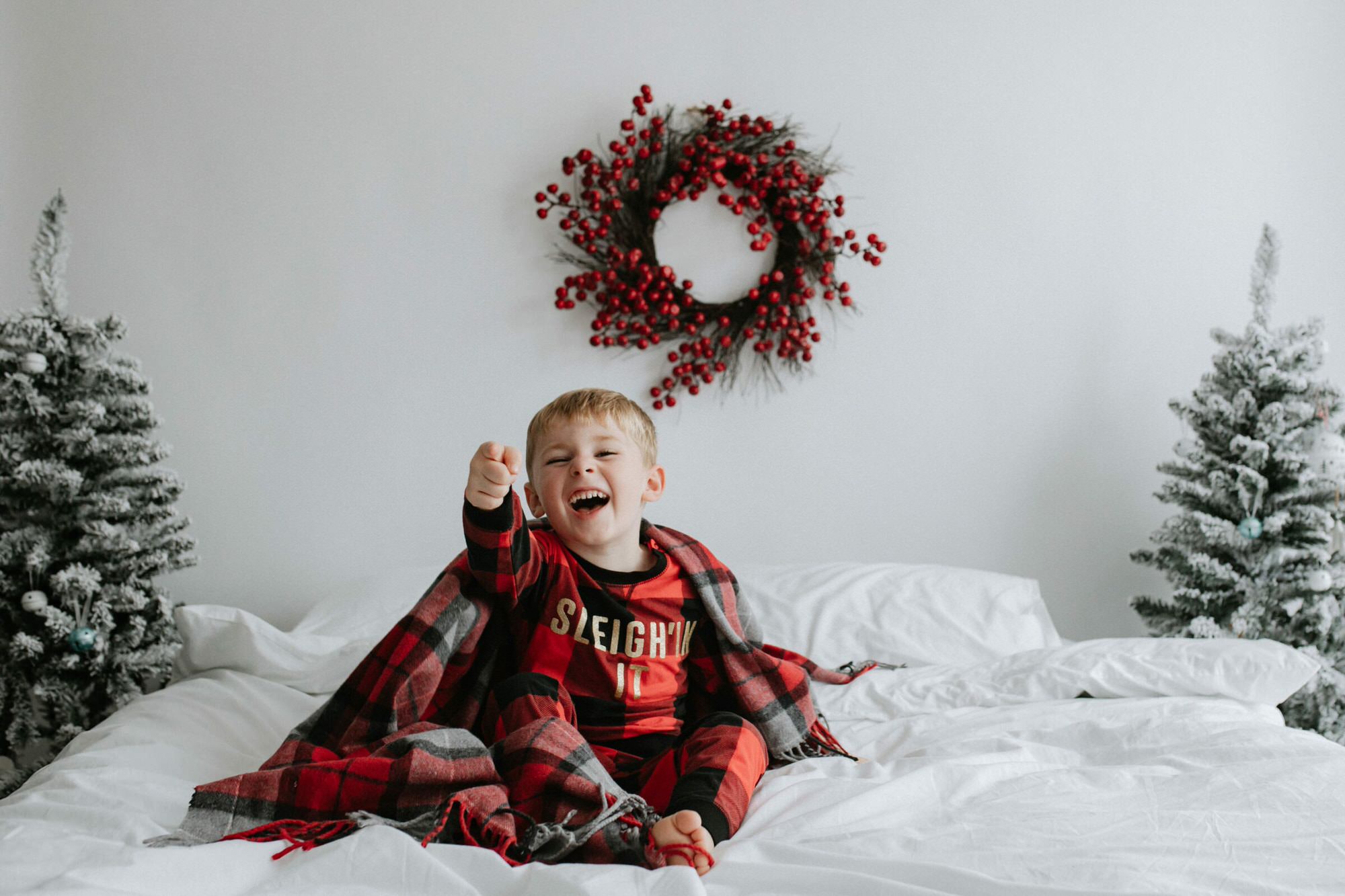 little boy on a white bed in a Christmas set up at a Kent Christmas mini photoshoot in Bexley