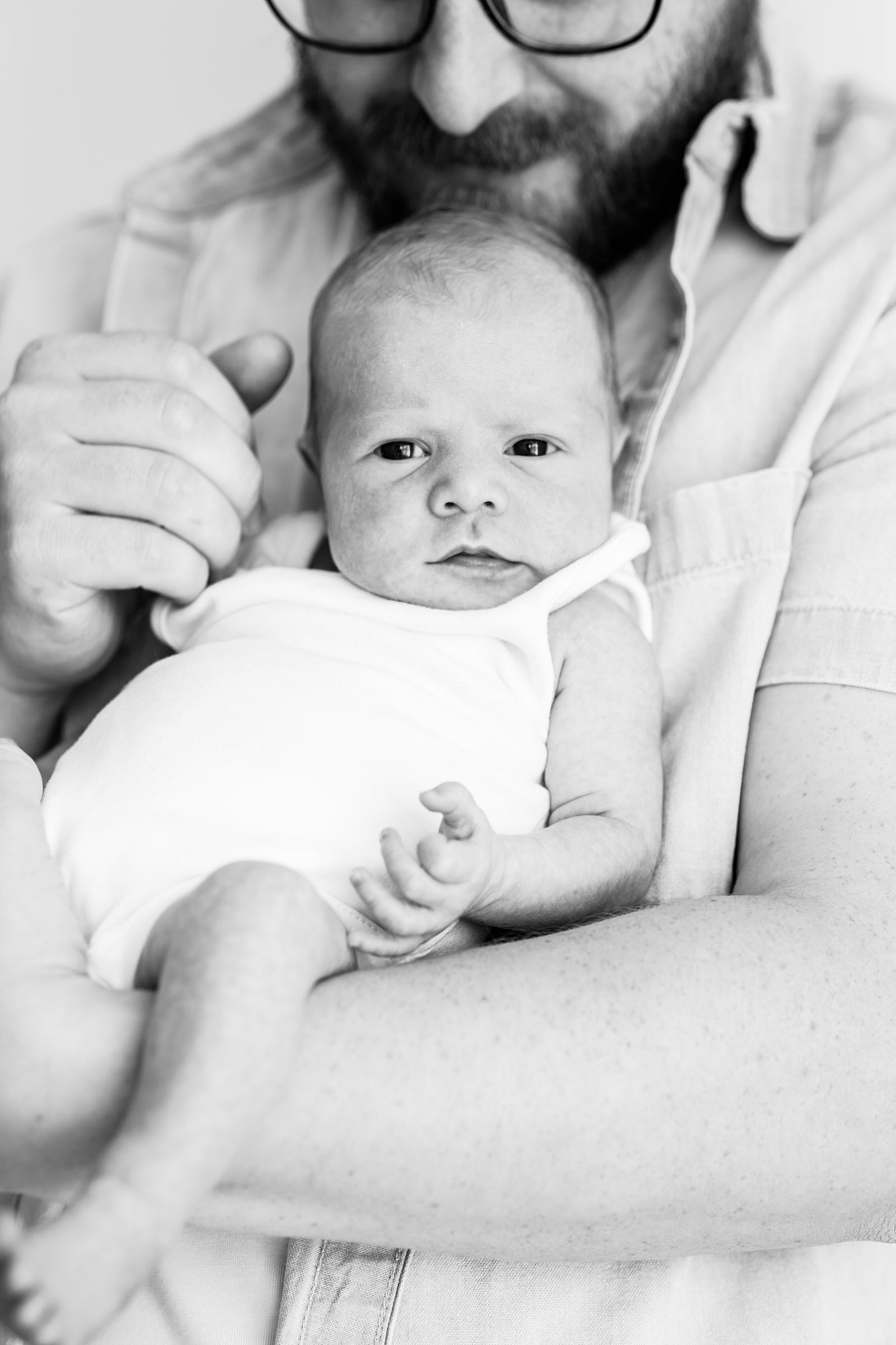 newborn baby with her daddy in black and white at her kent baby photoshoot in bexley