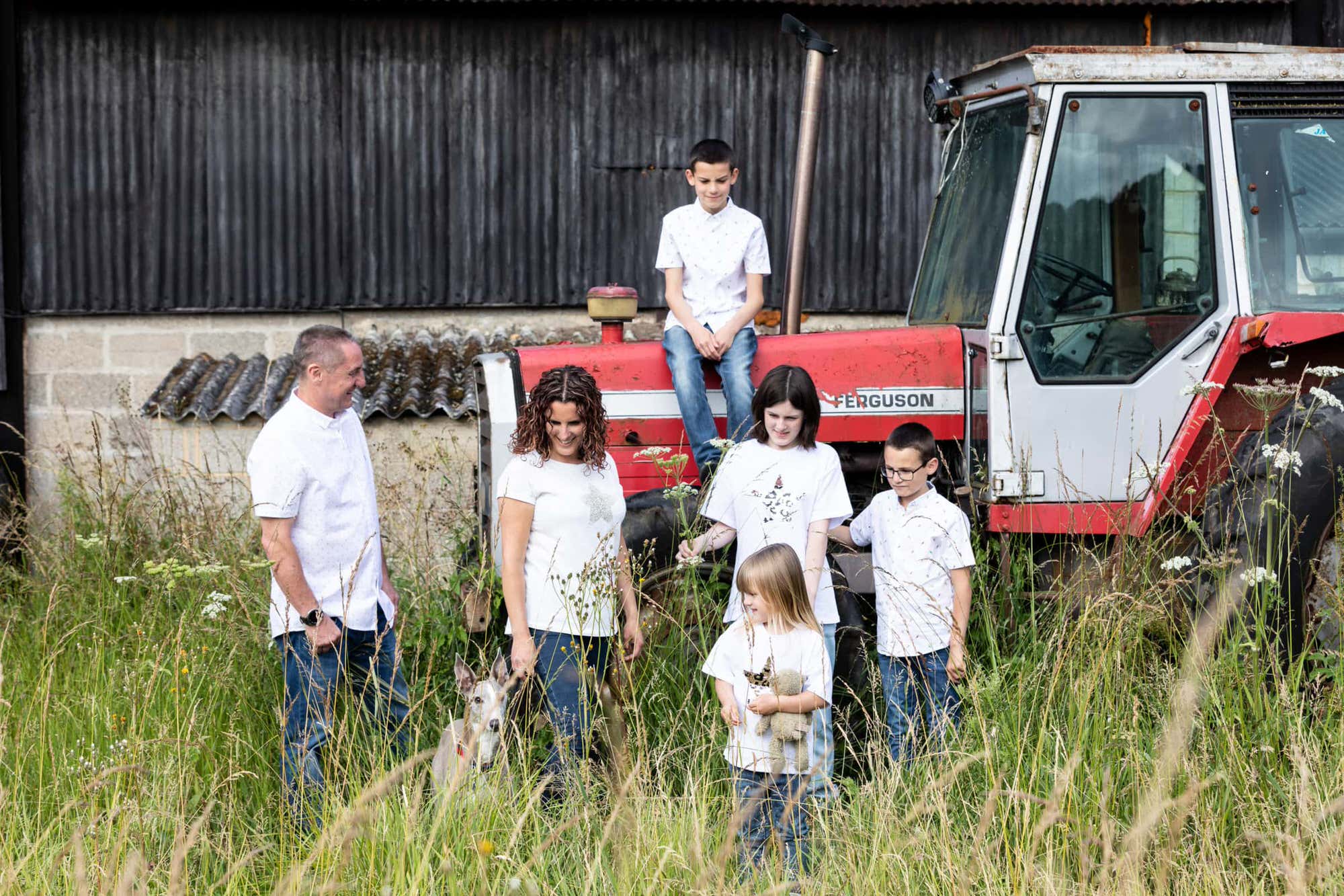 family of 6 sat on a vintage tractor at their kent wildflower photoshoot in Sevenoaks