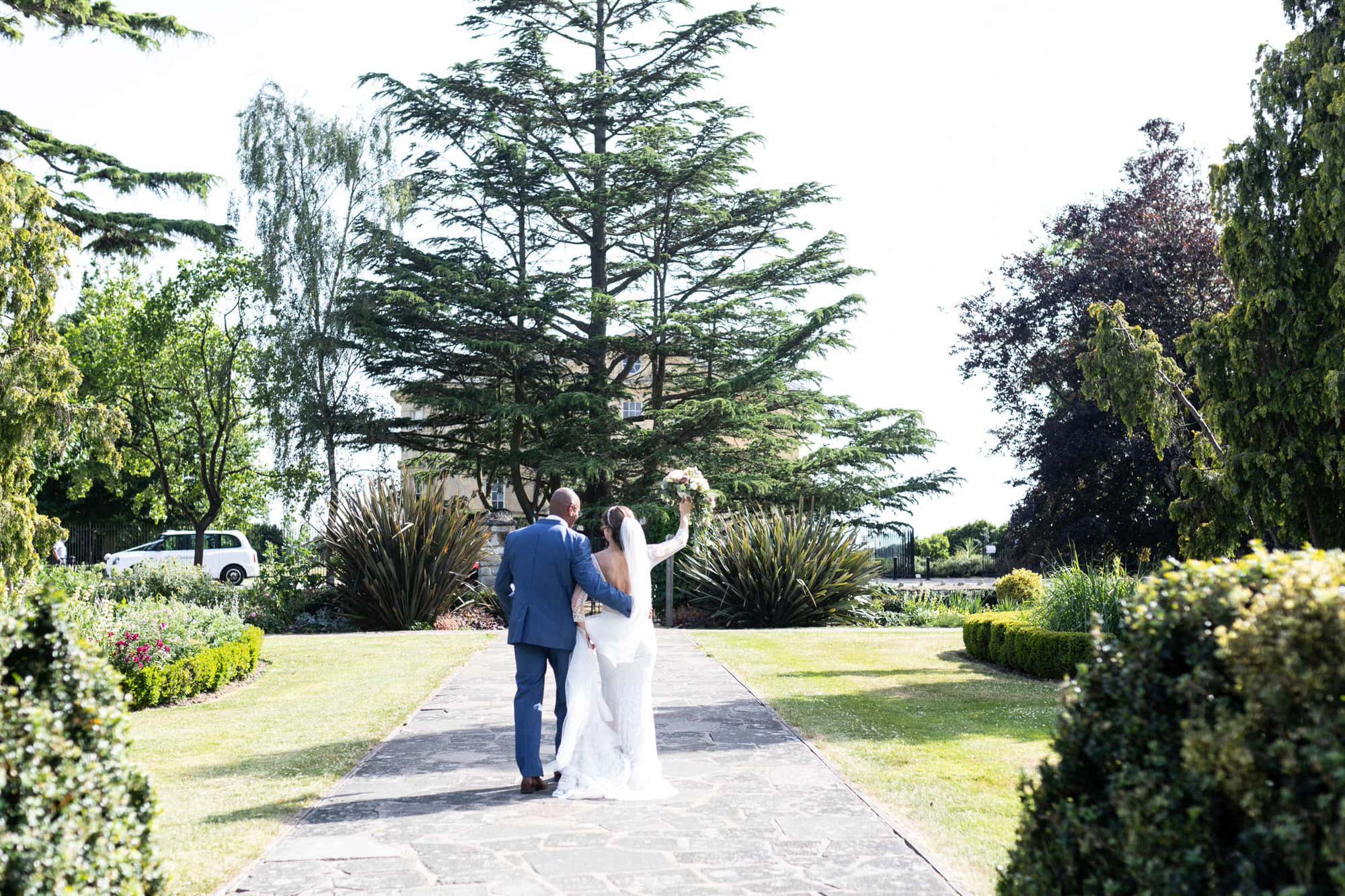 Bride and groom walking away from the camera after their wedding ceremony at Danson House Bexleyheat