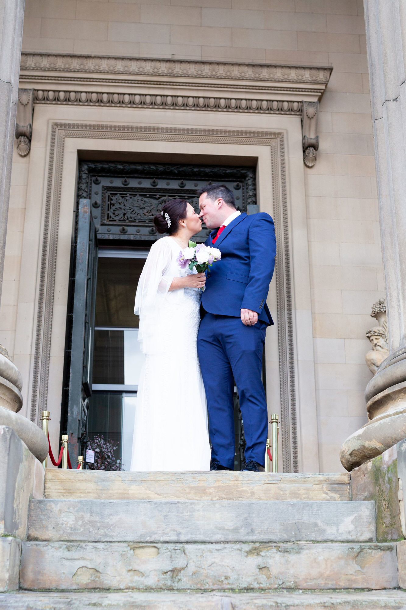 Bride and groom on the steps at St Georges Hall Liverpool Micro wedding shot by Kent wedding photographer