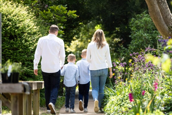 family of 4 walking away from the camera in beautiful light at their kent spring photoshoot in Sevenoaks