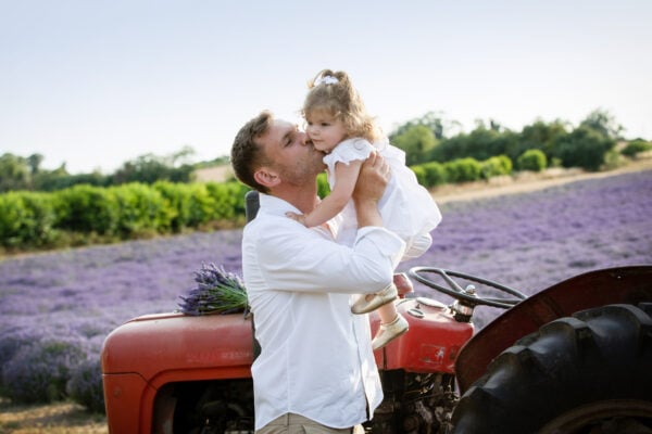 daddy and his little girl by a vintage tractor at their kent lavender family photoshoot in sevenoaks