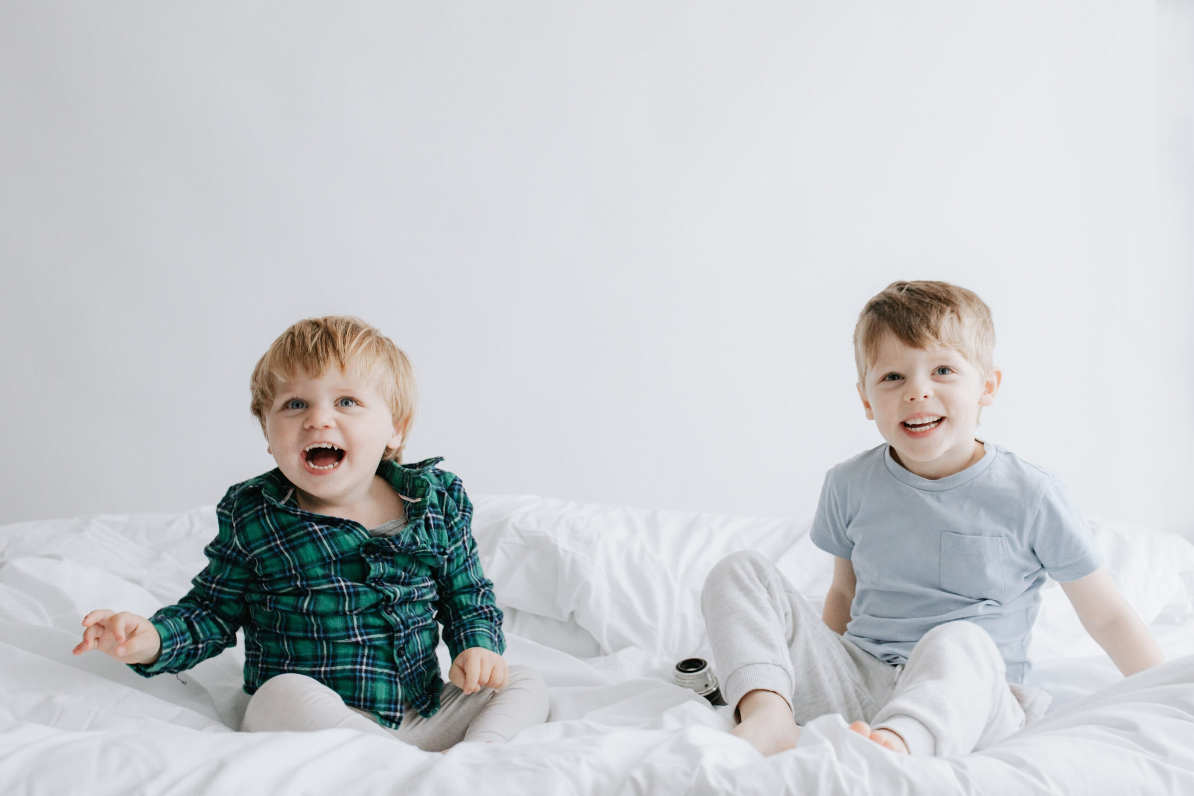 young boys bouncing on a bed laughing at their kent family photoshoot in bexley kent
