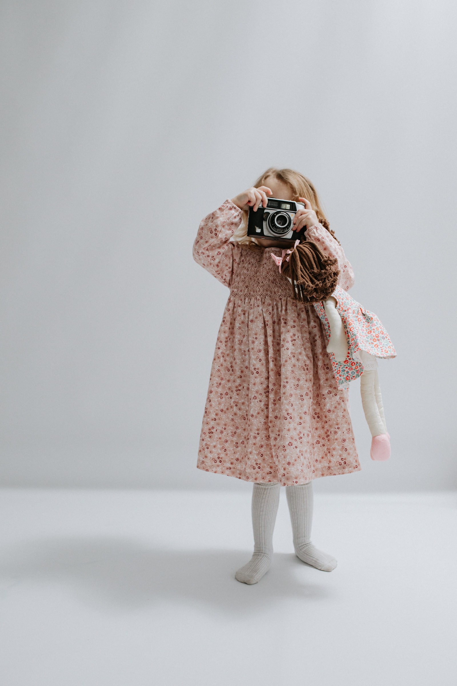 little girl taking a photo with a vintage camera at her kent family photoshoot in bexley