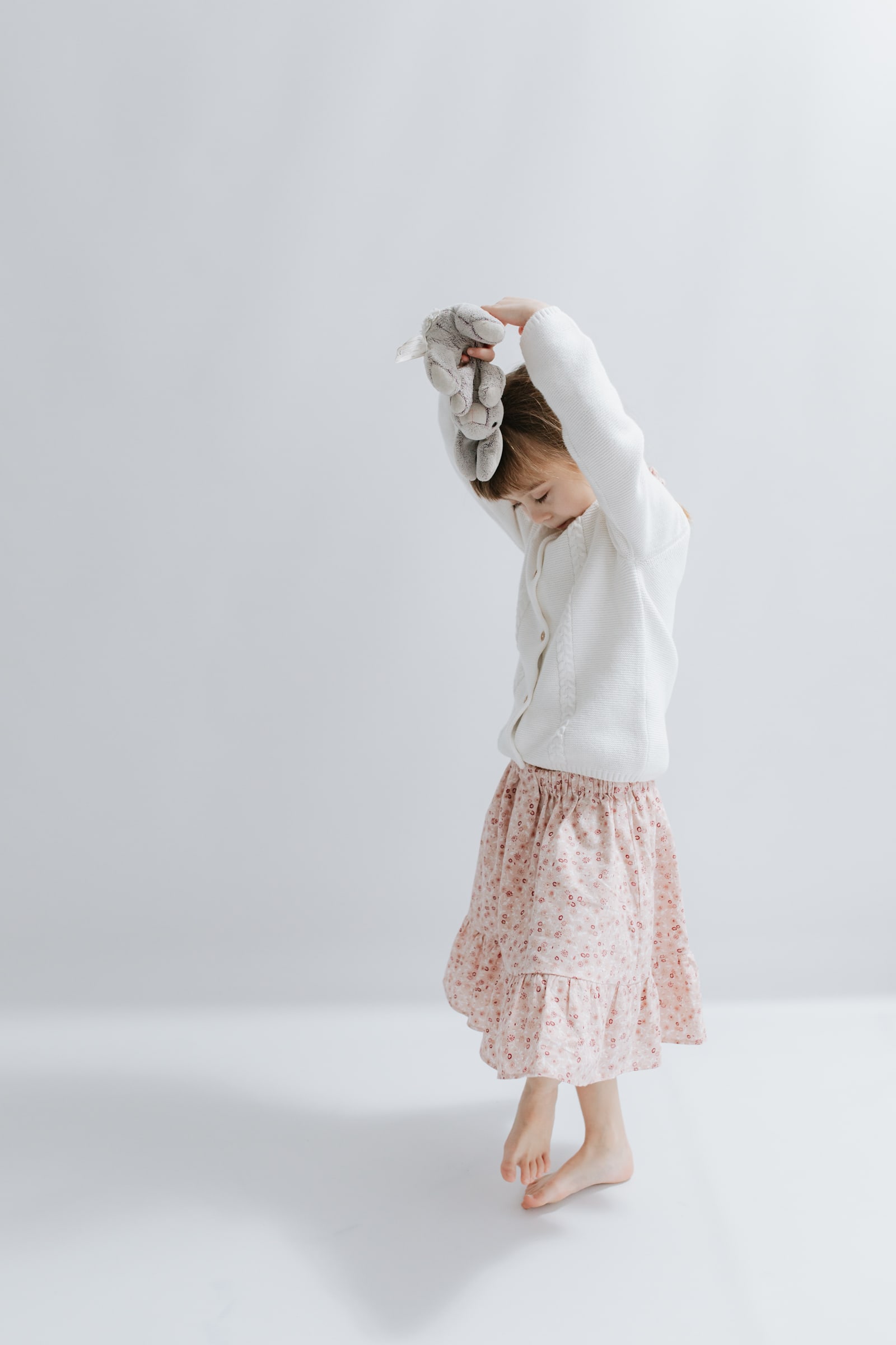 little girl dancing holding a toy bunny at her kent family photoshoot in bexley