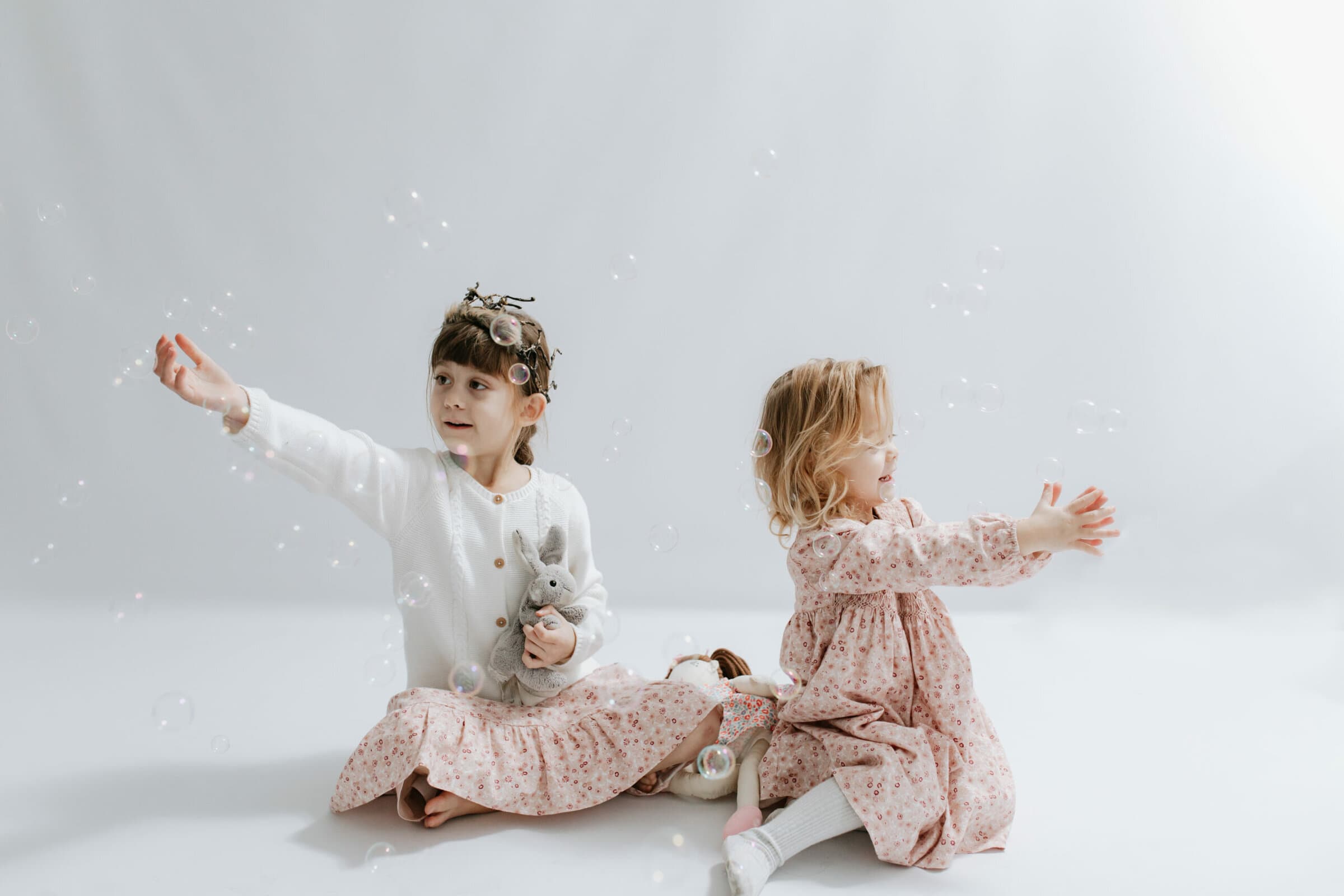 two sisters playing with bubbles at their kent family photoshoot in bexley
