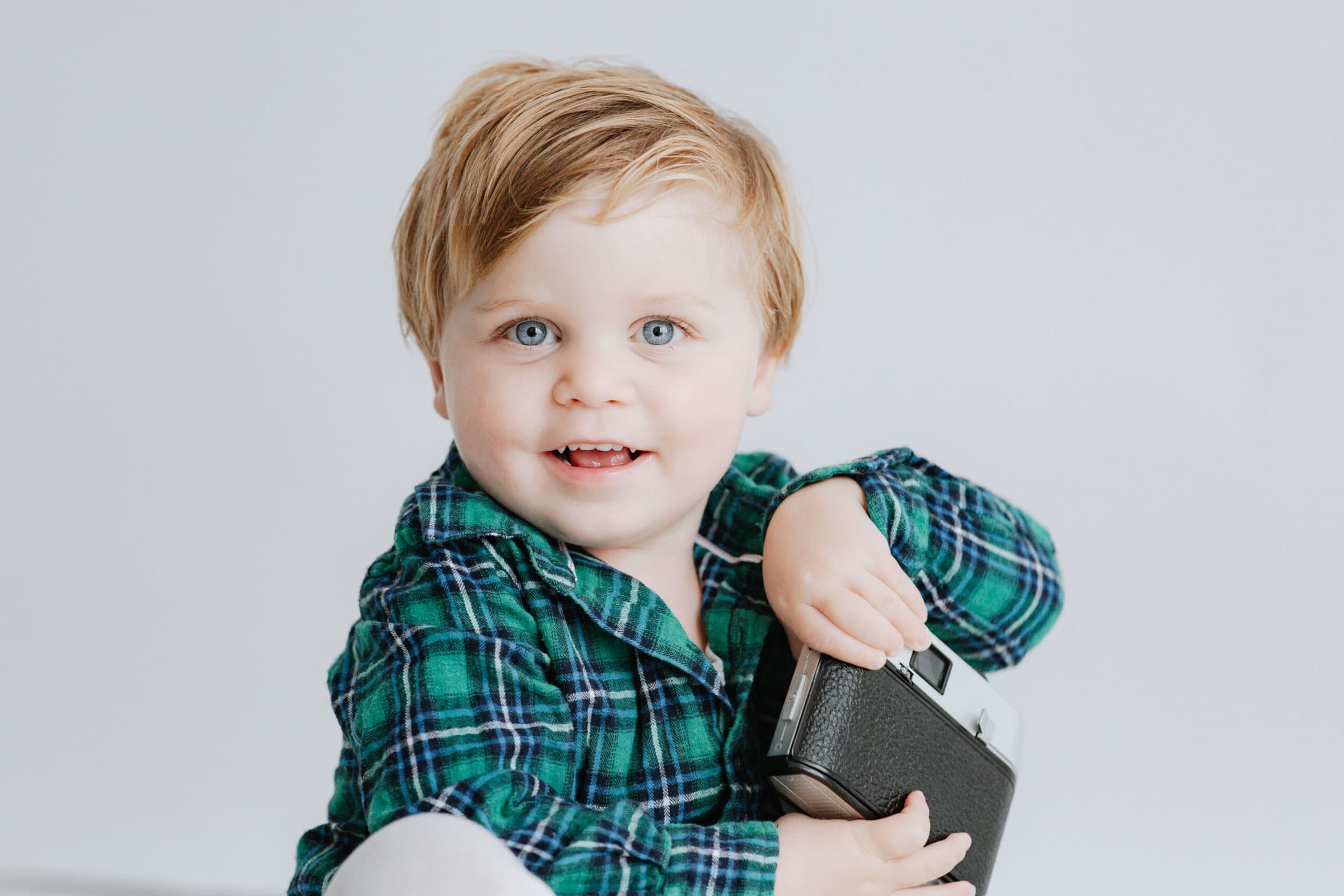 baby boy looking at the camera and smiling at his bexley family photoshoot in kent