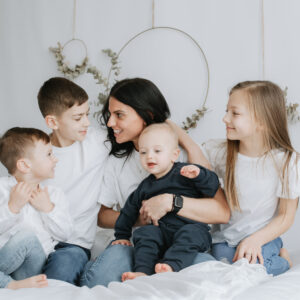 mummy sat on the bed with her 4 children at their Kent mummy and me photoshoot in Bexley for mothers day