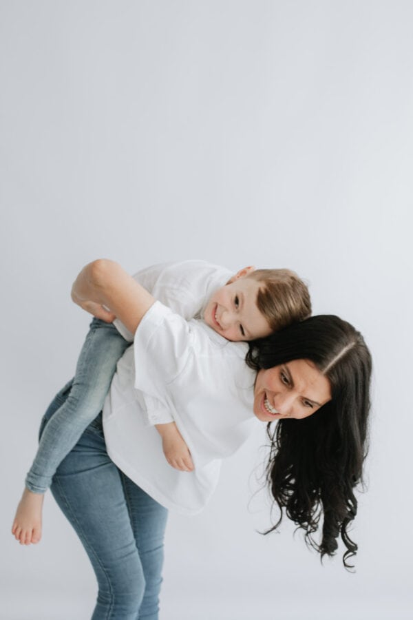 little boy on mummys back laughing at their Kent mummy and me photoshoot for mothers day in Bexley