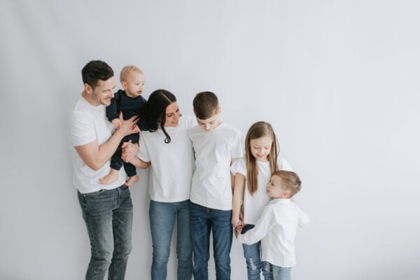 contemporary image of a family of 6 lined up against a white backdrop shot at a Kent mummy and me photoshoot in Bexley for mothers day