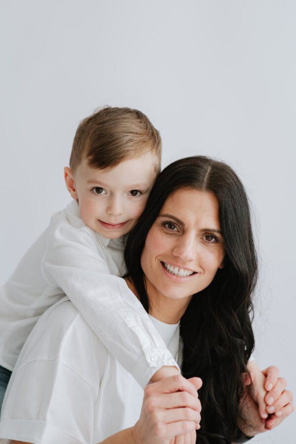 mummy and son leaning over her shoulders at her Kent mummy and me mini shoot for mothers day in Bexley