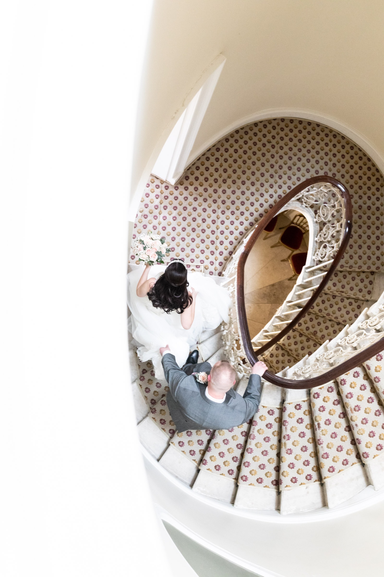 bride and groom descend the spiral staircase at Danson House Bexleyheath shot from above by Kent Micro wedding photographer in Bexley