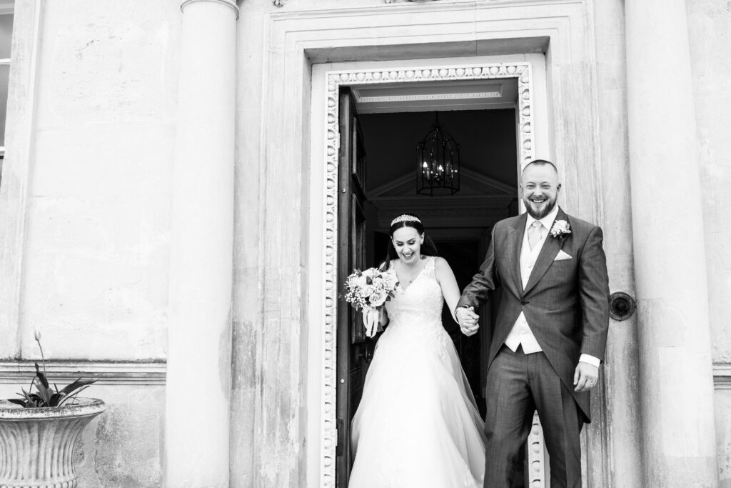bride and groom leaving the doorway at Danson House Bexleyheath micro wedding Kent
