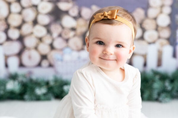 close up photograph of baby girl sat in a christmas scene at her bexley christmas mini photoshoot