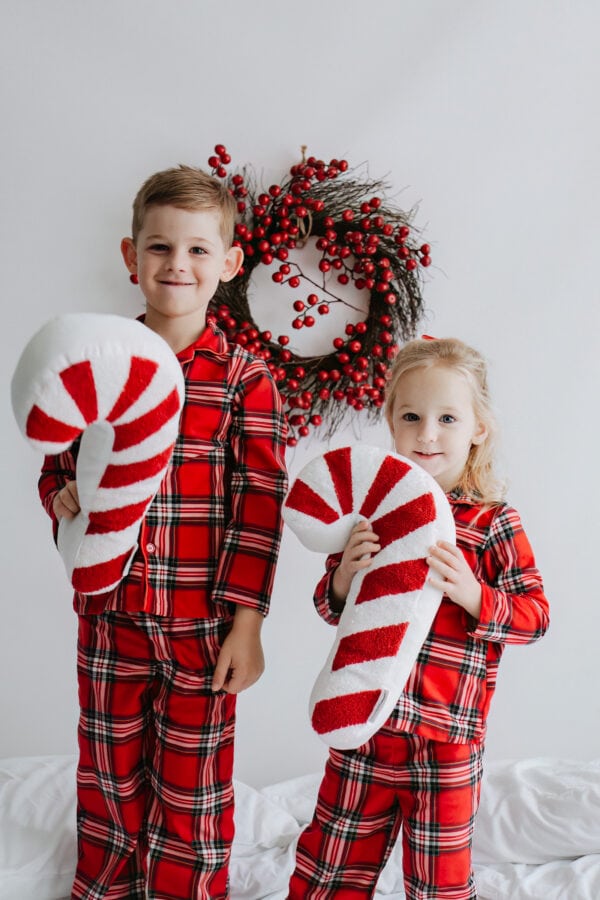 brother and sister in Christmas PJs with Candy Cane cushions at their bexley christmas photoshoot