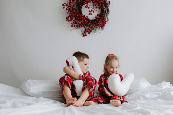 brother and sister in Christmas PJs with Candy Cane cushions at their bexley christmas photoshoot