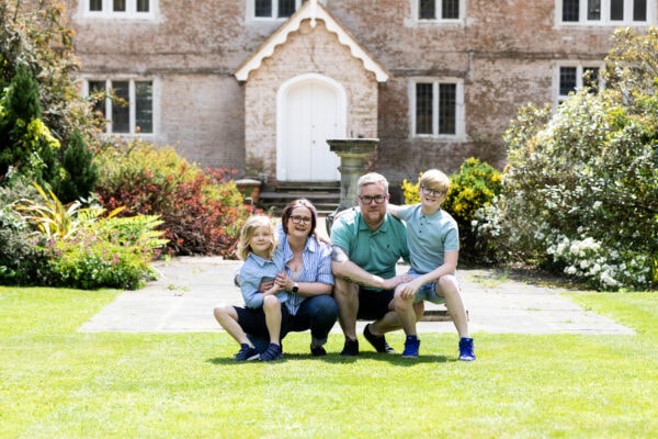 family of 4 in front of the great comp house at great comp gardens Sevenoaks for their family photoshoot