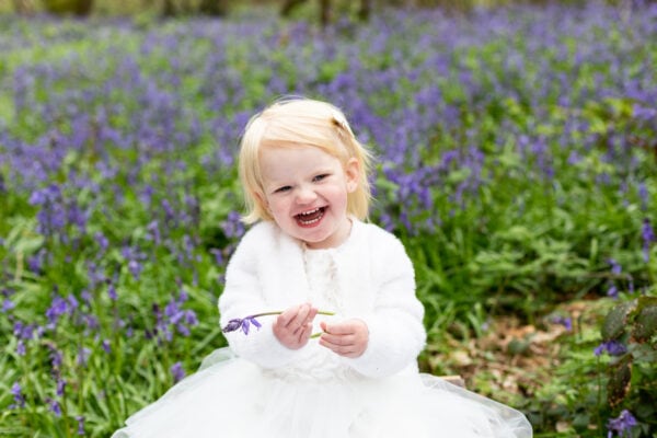 beautiful little girl laughing in the Kent bluebells at her Sevenoaks bluebell photoshoot